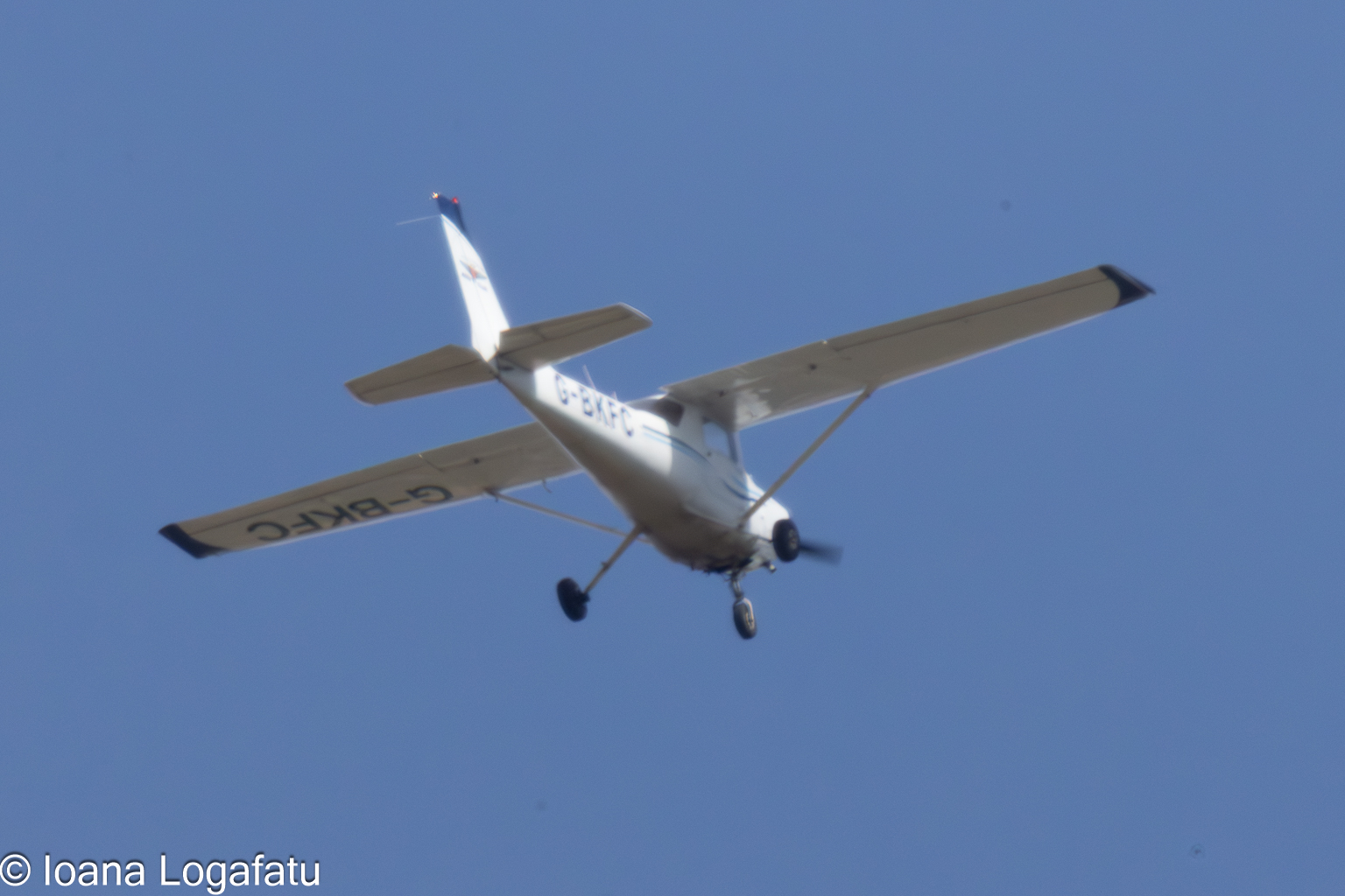 Small aircraft soaring across a clear blue sky